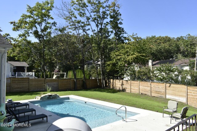 view of pool featuring a lawn and a patio