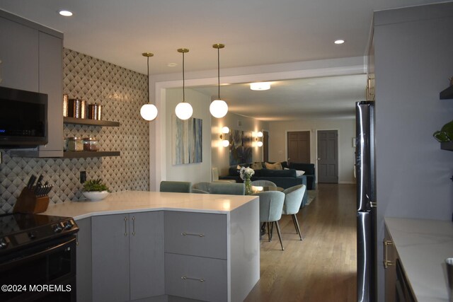 kitchen featuring decorative backsplash, gray cabinetry, dark hardwood / wood-style flooring, pendant lighting, and stainless steel appliances