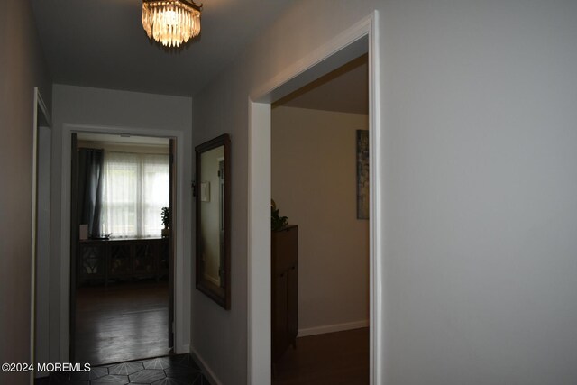 hall featuring dark hardwood / wood-style flooring and a notable chandelier