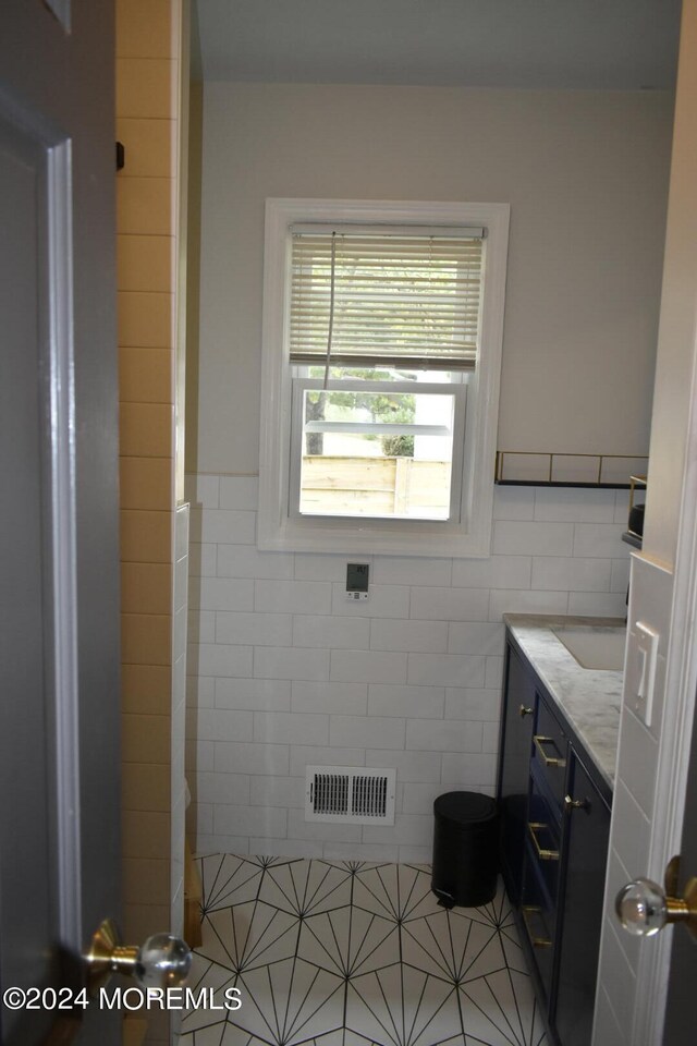 bathroom featuring tile walls, tile patterned flooring, and vanity