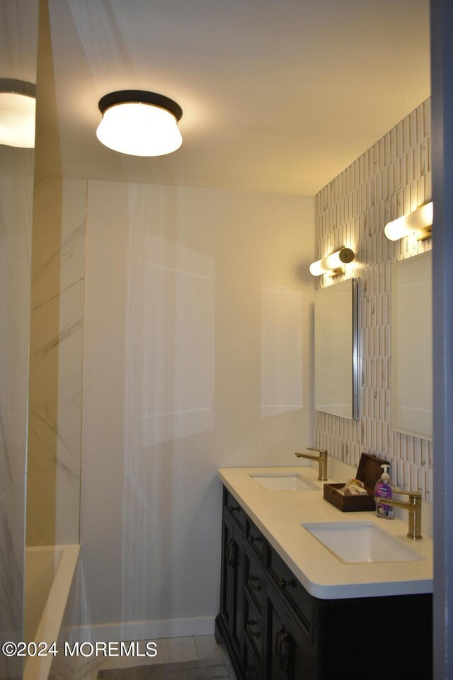 bathroom with a bathtub, decorative backsplash, vanity, and tile patterned floors