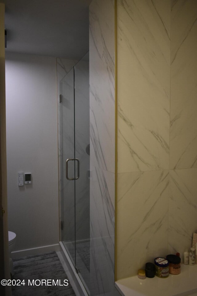 bathroom featuring toilet and an enclosed shower