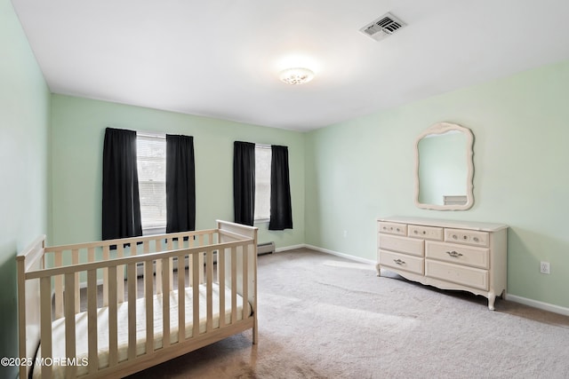 bedroom featuring a baseboard heating unit, carpet, visible vents, and baseboards