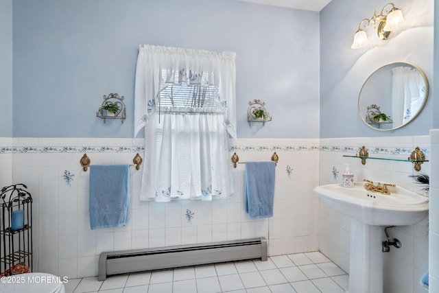 bathroom with toilet, wainscoting, a baseboard radiator, and tile walls