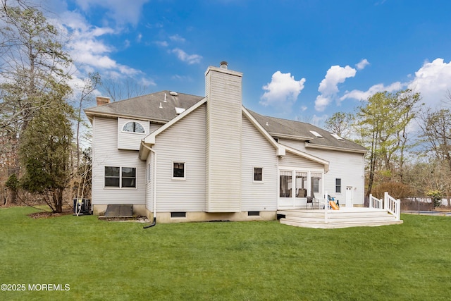 back of house with a deck, a lawn, and a chimney