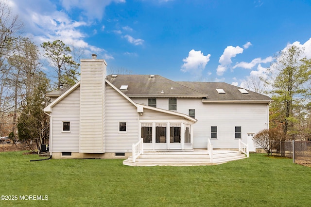 back of house featuring a sunroom, a lawn, a chimney, and fence