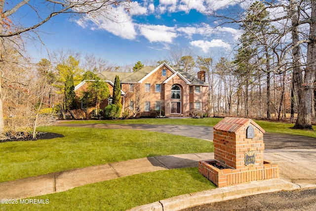 view of front of house featuring a chimney and a front lawn