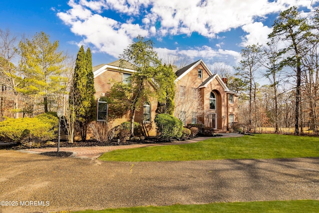 view of front of home featuring a front yard and brick siding