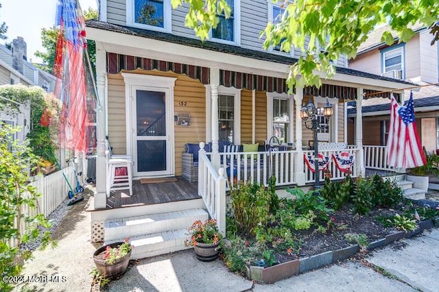 entrance to property featuring fence and a porch