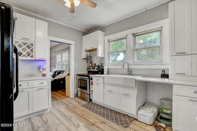 kitchen featuring crown molding, white cabinetry, stainless steel range with electric cooktop, and light hardwood / wood-style flooring