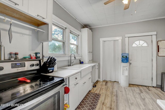 kitchen featuring white cabinets, stainless steel electric stove, and a healthy amount of sunlight