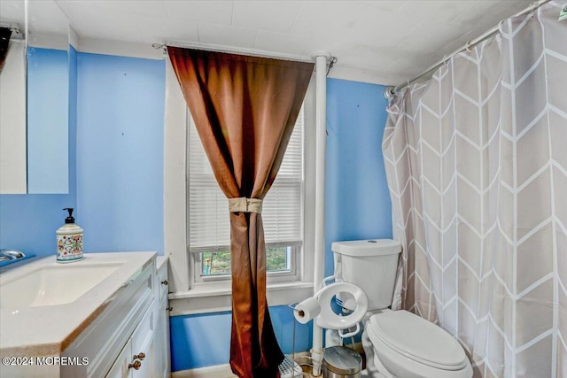 bathroom featuring curtained shower, vanity, and toilet