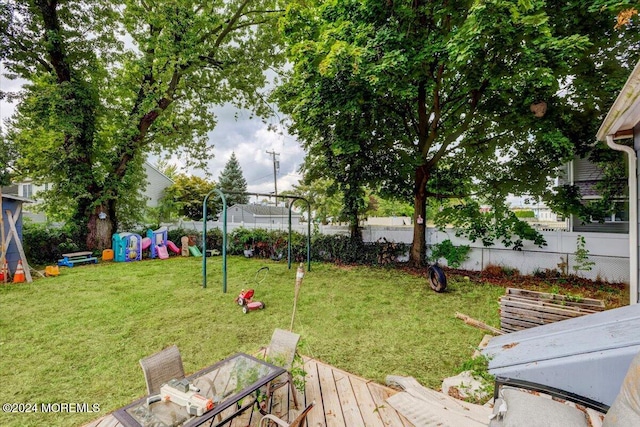 view of yard with a wooden deck and a playground