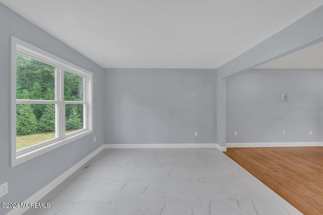 unfurnished room with light wood-type flooring and plenty of natural light