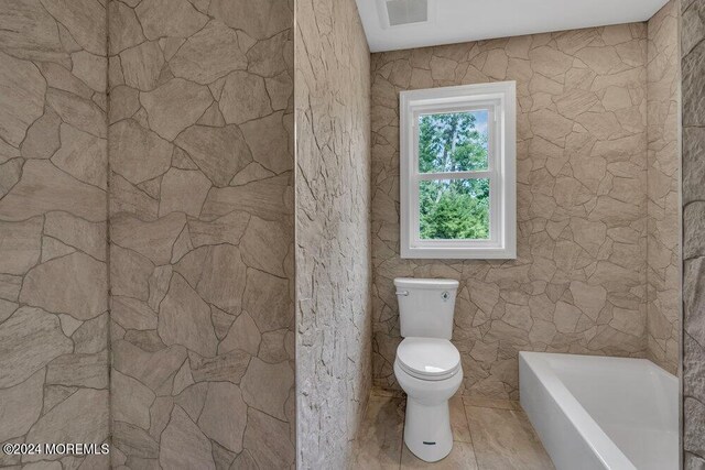 bathroom with toilet and a washtub