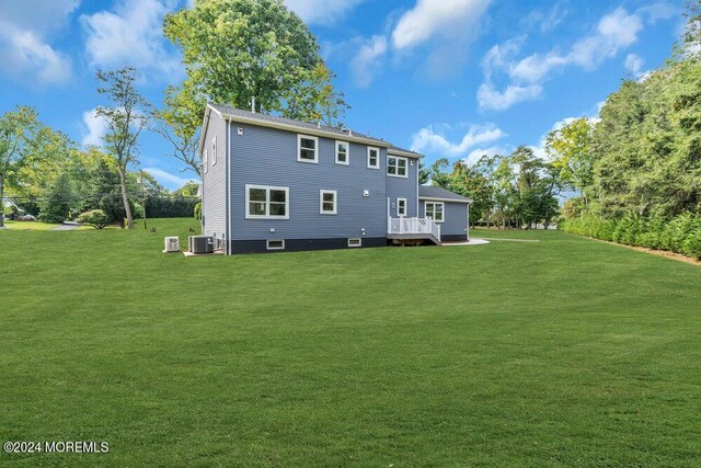 back of house with a lawn, a wooden deck, and cooling unit