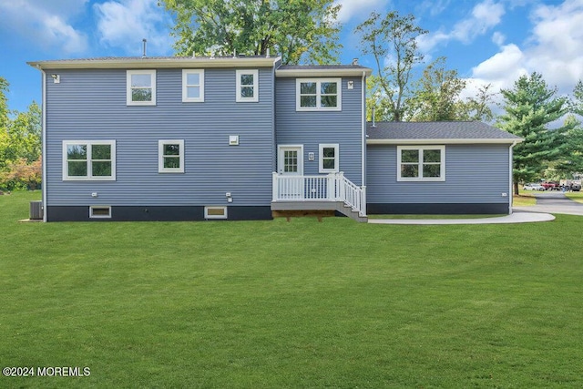 rear view of house featuring a yard and central AC