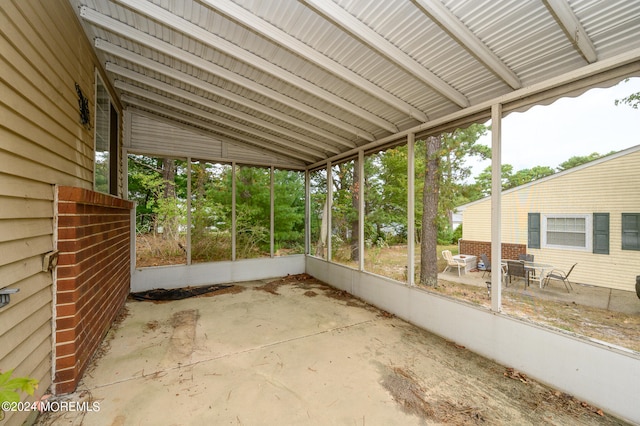 unfurnished sunroom featuring vaulted ceiling