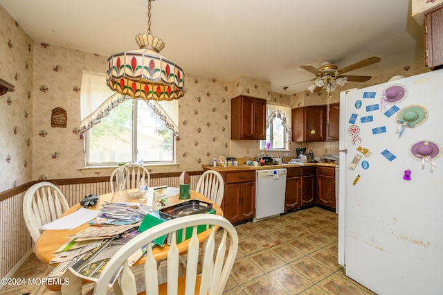 kitchen featuring hanging light fixtures, white appliances, light tile patterned floors, and ceiling fan