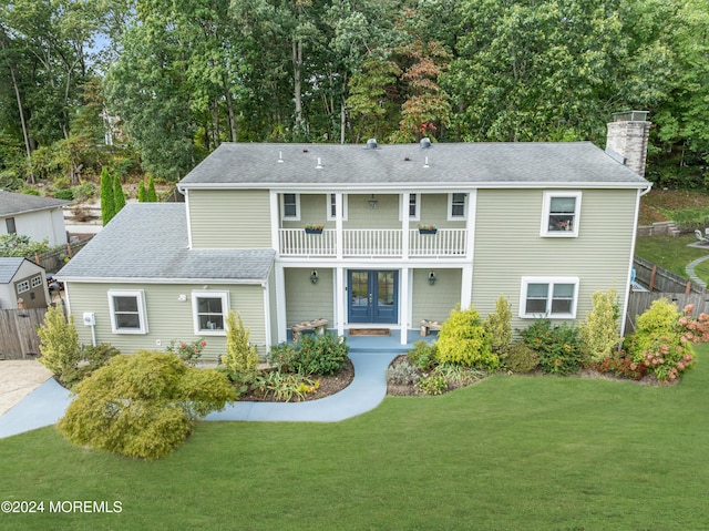 back of house featuring a yard, french doors, a balcony, and fence