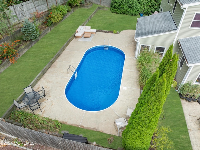 view of swimming pool featuring a patio area, a fenced in pool, a fenced backyard, and a lawn