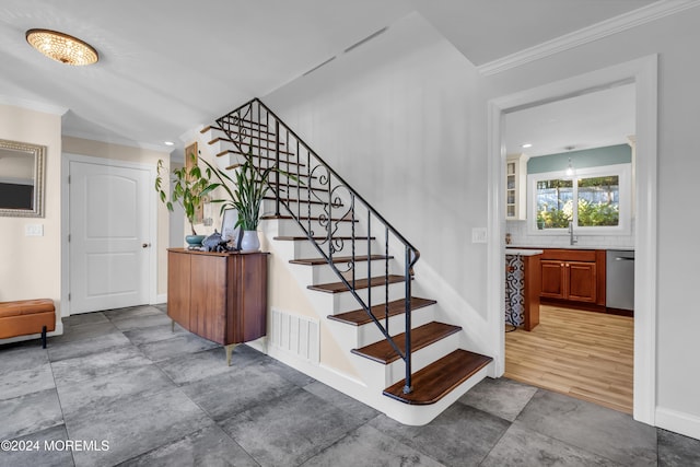 stairway with baseboards, visible vents, and ornamental molding