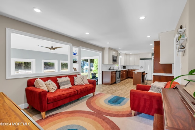 living room with recessed lighting, light wood-type flooring, and baseboards