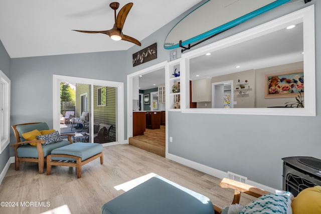 living room with a ceiling fan, wood finished floors, visible vents, baseboards, and lofted ceiling