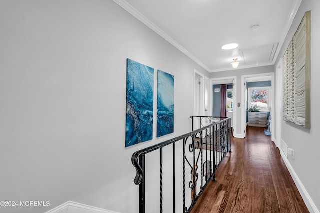 corridor featuring an upstairs landing, wood finished floors, crown molding, baseboards, and attic access