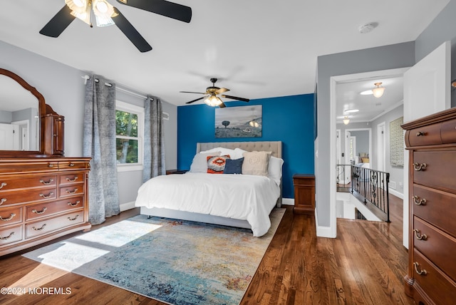 bedroom featuring a ceiling fan, wood finished floors, and baseboards