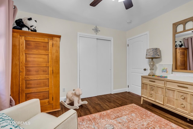 bedroom with a ceiling fan, dark wood-style flooring, a closet, and baseboards