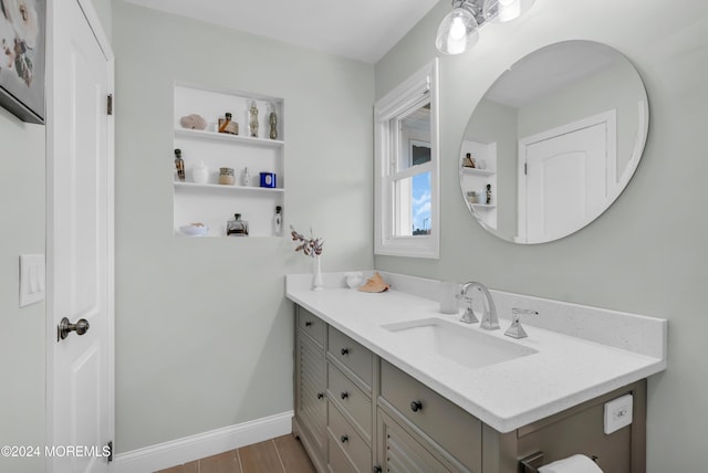 bathroom with vanity, baseboards, and wood finished floors