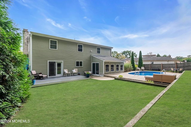 rear view of property with fence, a fenced in pool, a yard, a chimney, and a deck