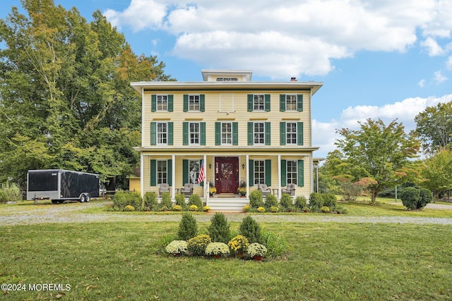 italianate home with a front yard and a porch
