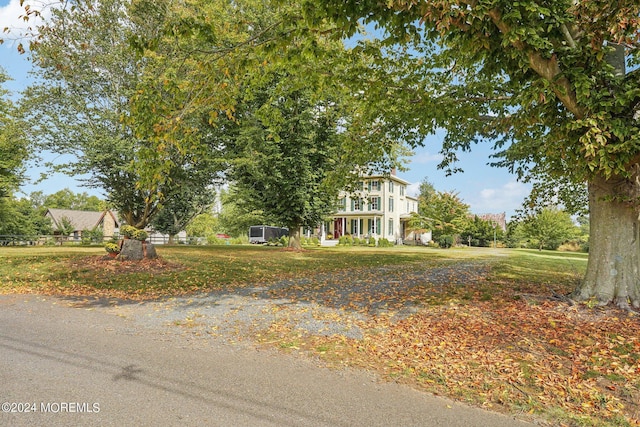 view of property hidden behind natural elements with a front lawn