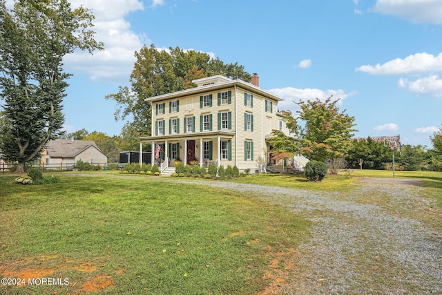 view of front of house featuring fence, driveway, a chimney, and a front lawn