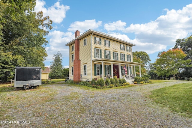 view of front of house featuring a chimney and a front lawn