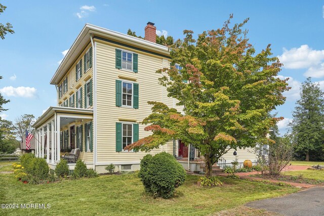 view of front of home with a front yard and a chimney