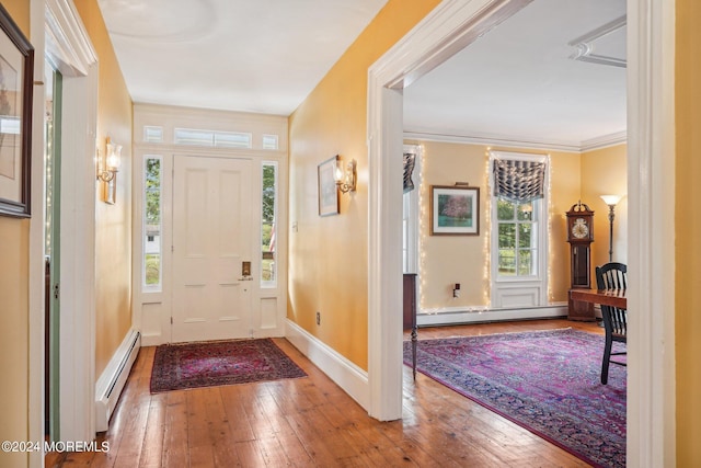 entrance foyer with a baseboard radiator, a baseboard heating unit, a wealth of natural light, and hardwood / wood-style flooring