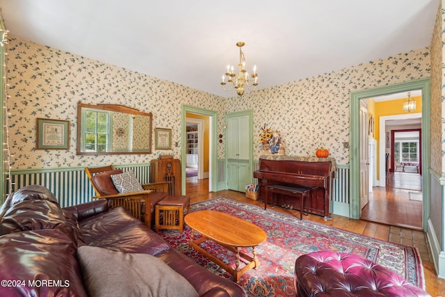 living room featuring wallpapered walls, an inviting chandelier, and hardwood / wood-style flooring
