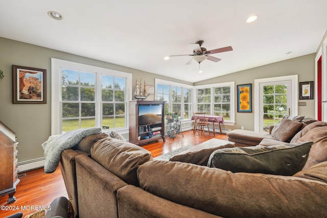 living area with lofted ceiling, a baseboard heating unit, wood finished floors, and ceiling fan