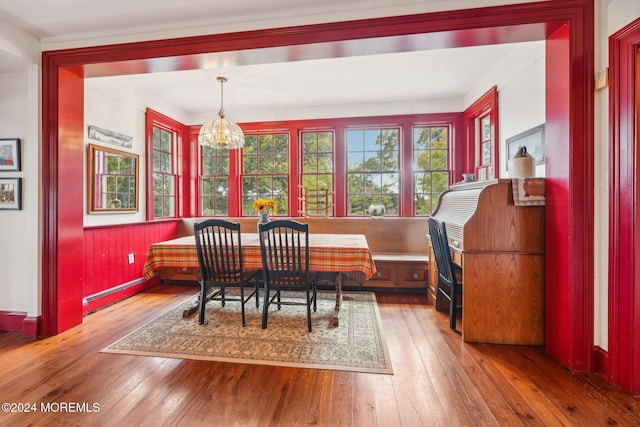 dining space with baseboard heating, a notable chandelier, hardwood / wood-style flooring, and breakfast area
