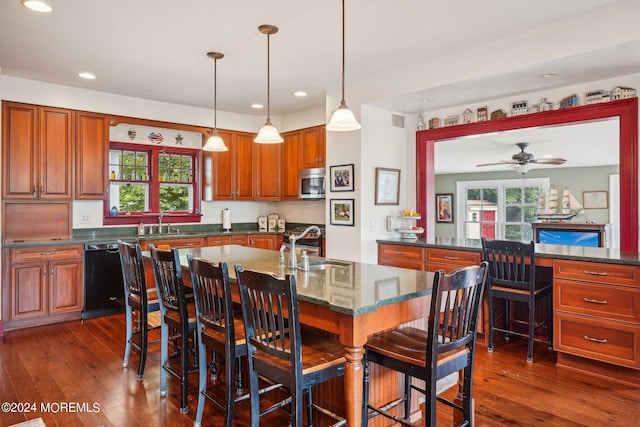 kitchen with stainless steel microwave, plenty of natural light, dishwasher, and a sink