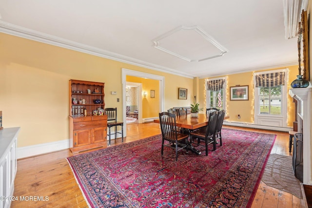 dining space featuring light wood-type flooring, a baseboard radiator, and crown molding