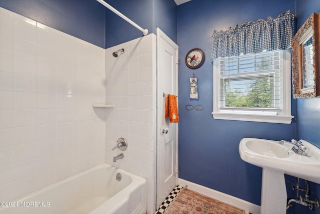 bathroom with baseboards, a sink, and tub / shower combination