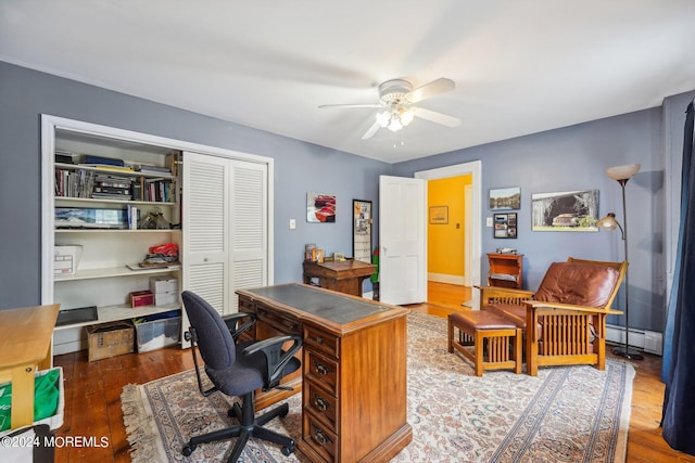 office area with baseboard heating, wood finished floors, and ceiling fan
