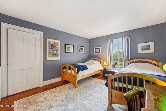 bedroom with hardwood / wood-style flooring and baseboards