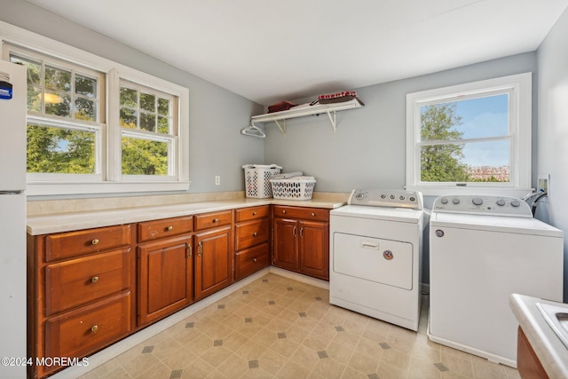washroom featuring washer and dryer, cabinet space, and a wealth of natural light