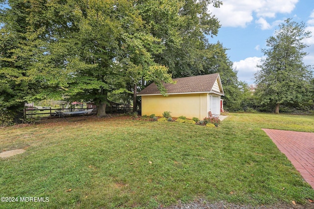 view of yard featuring fence and an outbuilding