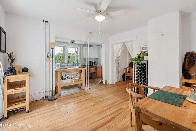 dining area with light wood-type flooring and ceiling fan